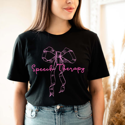 Person wearing a black t-shirt with a pink bow and 'Speech Therapy' text.