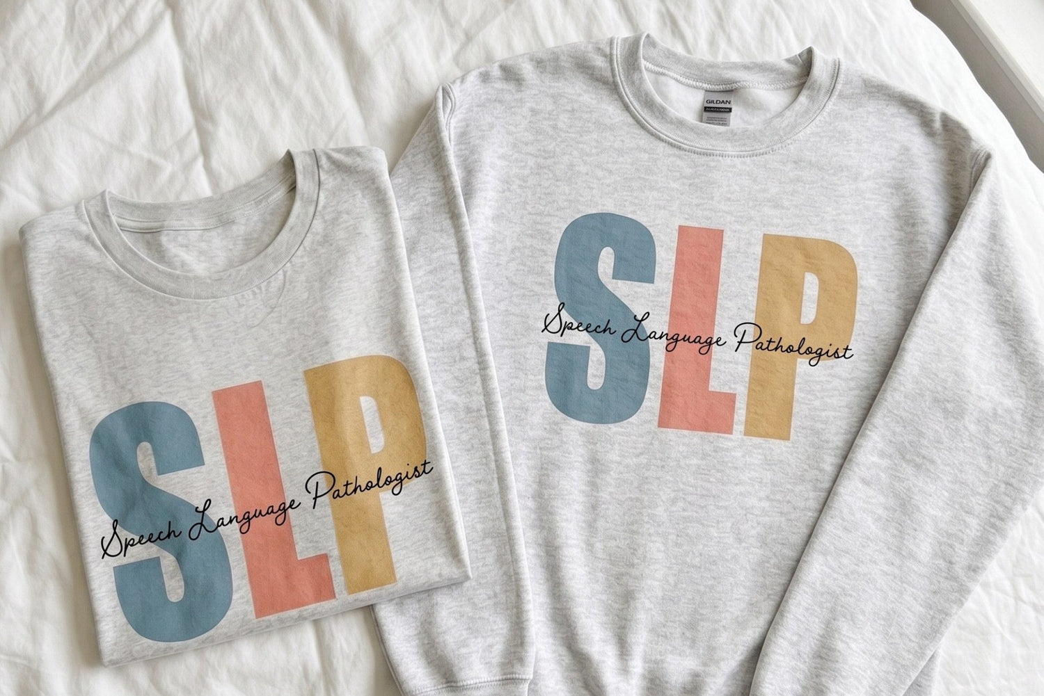 Gray sweatshirt with colorful 'SLP' letters and text on a white surface